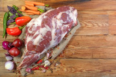 Çuval bezi, soğan, sarımsak, biber, tuz, biberiye ve sebze yağının üzerine işlenmemiş bir koyun bacağı. Yakın plan koyun eti. Taze koyun eti. Yukarıdan görünüşü.