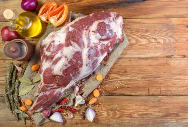 Çuval bezi, soğan, sarımsak, biber, tuz, biberiye ve sebze yağının üzerine işlenmemiş bir koyun bacağı. Yakın plan koyun eti. Taze koyun eti. Yukarıdan görünüşü.