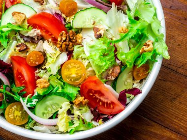 Farklı türde salata, domates, soğan, salatalık ve fındık..