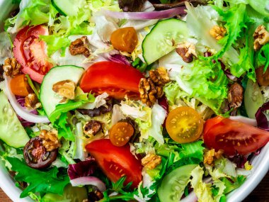 Farklı türde salata, domates, soğan, salatalık ve fındık..