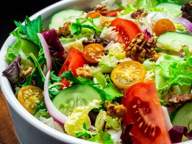 Farklı türde salata, domates, soğan, salatalık ve fındık..