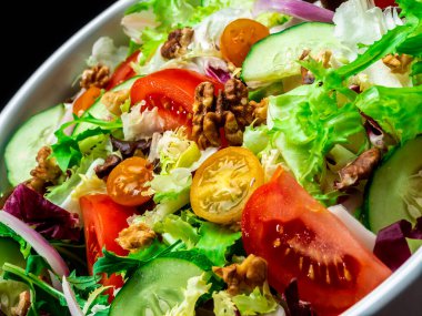 Farklı türde salata, domates, soğan, salatalık ve fındık..