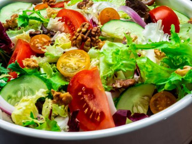 Farklı türde salata, domates, soğan, salatalık ve fındık..