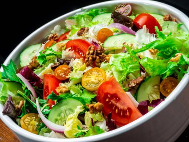 Farklı türde salata, domates, soğan, salatalık ve fındık..