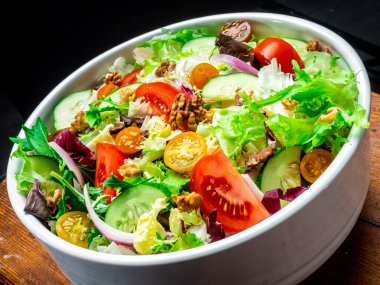 Farklı türde salata, domates, soğan, salatalık ve fındık..