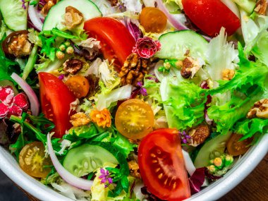 Farklı türde salata, domates, soğan, salatalık ve fındık..