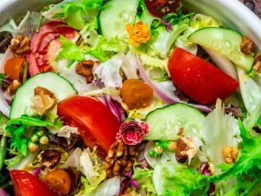 Farklı türde salata, domates, soğan, salatalık ve fındık..