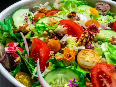 Farklı türde salata, domates, soğan, salatalık ve fındık..