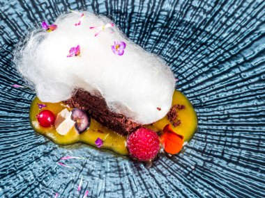 Pamuk şekerli çikolatalı kek ve mango soslu kırmızı meyve.