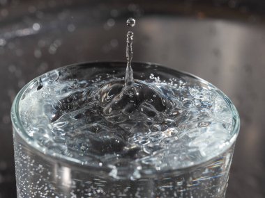 İçine bir damla su düştükten sonra bir bardağın su yüzeyinde türbülans.