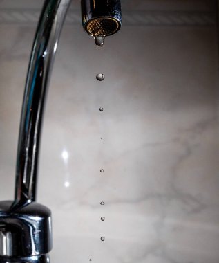 Kötü kapatılmış bir musluk su sızdırıyor.