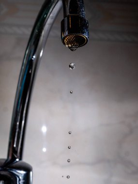 Kötü kapatılmış bir musluk su sızdırıyor.