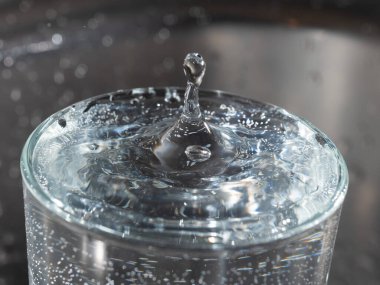 İçine bir damla su düştükten sonra bir bardağın su yüzeyinde türbülans.