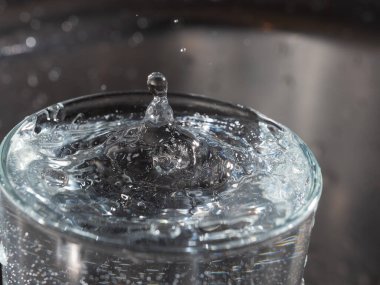 İçine bir damla su düştükten sonra bir bardağın su yüzeyinde türbülans.