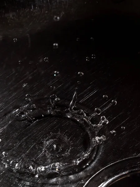 Splash produced by a drop of water crashing on the metal surface of a sink.