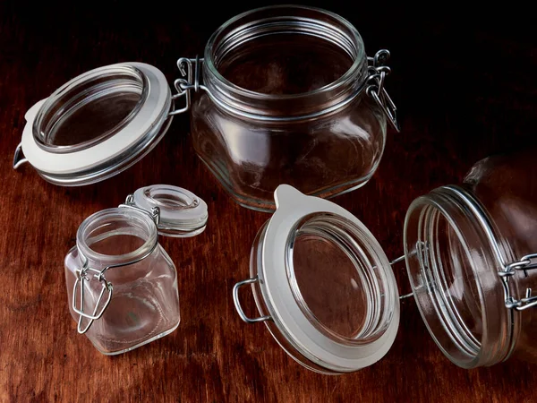 Empty glass jars with open lids are held in place with a metal wire.