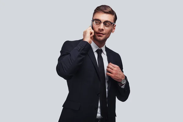 Bonito Jovem Empresário Falando Telefone Inteligente Olhando Para Longe Estúdio — Fotografia de Stock