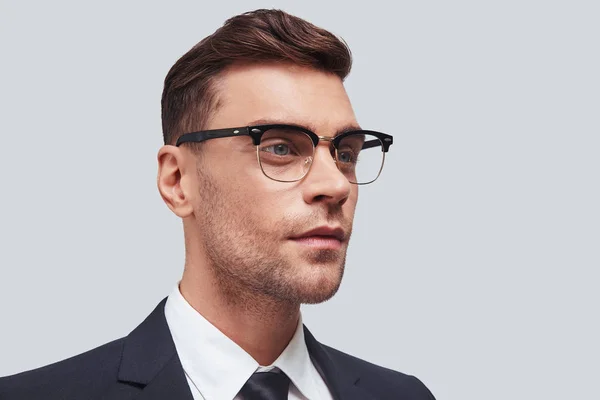 Omtänksam Ung Man Glasögon Tittar Bort Stående Mot Grå Bakgrund — Stockfoto