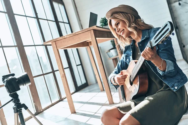 Hermosa Joven Tocando Guitarra Sonriendo Mientras Graba Vídeo Cámara Casa —  Fotos de Stock