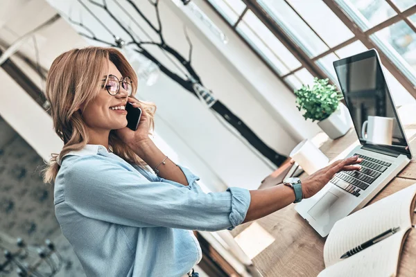 Vacker Blond Kvinna Använder Bärbar Dator Och Pratar Mobiltelefon Med — Stockfoto