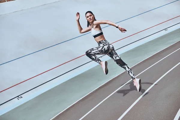 Bunu yapabilirsin! Güzel genç kadın spor giyim çalışan açık havada egzersiz sırasında