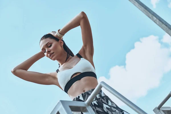 Brunette Vrouw Sportkleding Poseren Tegen Blauwe Hemel — Stockfoto