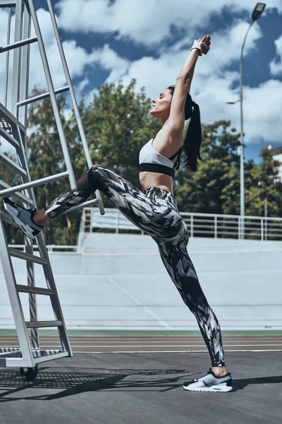 Açık havada germe giyim spor genç kadının tam uzunlukta