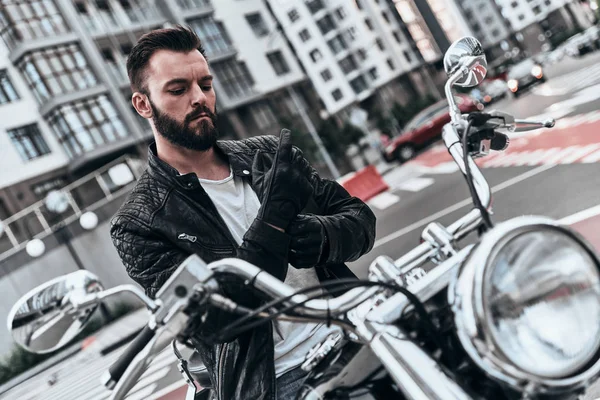 モーターサイク リスト男のバイクに座っていると手袋を調整 — ストック写真