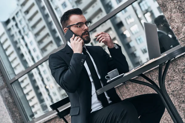 Homem Negócios Falando Telefone Inteligente Enquanto Sentado Café Mesa Com — Fotografia de Stock