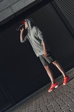 Genç adam açık havada dinlenme ve içme suyu giyim spor 