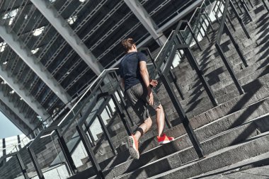 tam uzunlukta, Spor Stadyumu merdiven üzerinde çalışan giyim adam arkadan görünüm 
