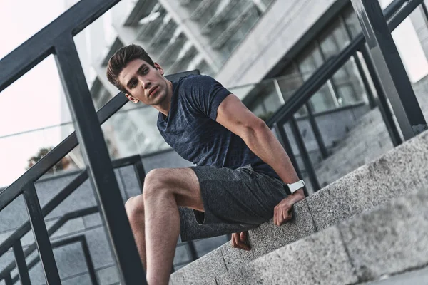 Young Man Sports Clothing Looking Away While Sitting Stairs — Stock Photo, Image