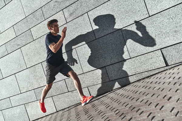 Knappe Jongeman Sportkleding Uitgevoerd Stad Straat Stenen Muur — Stockfoto