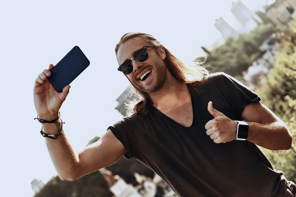 Fiatal Férfi Alkalmi Ruházat Intett Thumbs Fel Mosolyogva Miközben Selfie — Stock Fotó