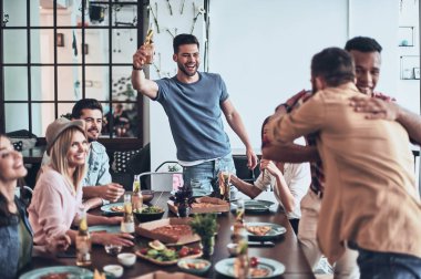 Kızartma ve kucaklayan iki adam gülümseyen yakışıklı delikanlı