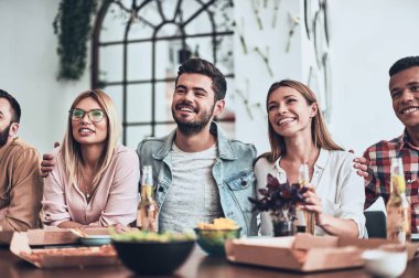 masada rahat kıyafet bir akşam yemeği yerken gülümseyen insanlar parti 