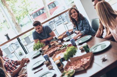 konuşmak ve yemek yerken gülümseyen şık restoranda parti