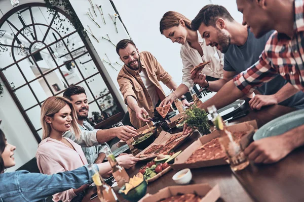 Grupo Jovens Roupas Casuais Comer Sorrir Enquanto Faz Jantar — Fotografia de Stock