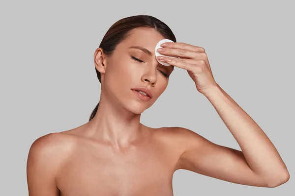 Mujer Aplicando Almohadilla Algodón Manteniendo Los Ojos Cerrados Estudio —  Fotos de Stock