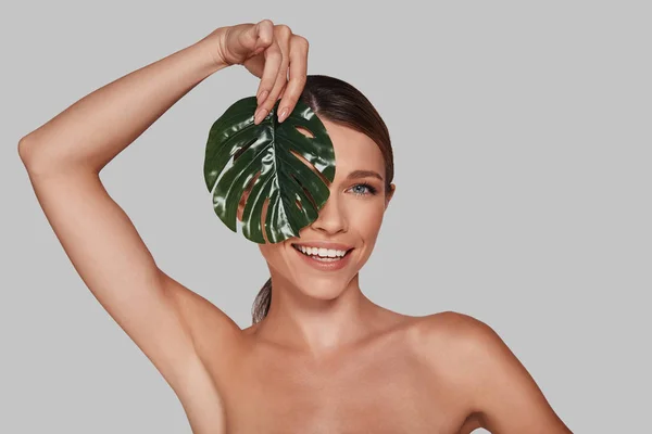 Attraente Giovane Donna Guardando Fotocamera Coprendo Viso Con Foglia Studio — Foto Stock