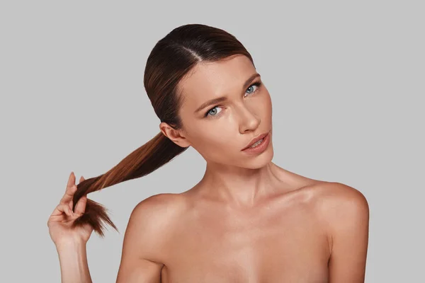 Atraente Jovem Mulher Tocando Seu Cabelo Enquanto Posando Estúdio — Fotografia de Stock