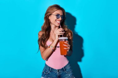 mutlu gülümseyen esmer kadın stüdyoda kokteyl içme 