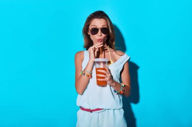 muhteşem bir esmer genç kadın mavi Studio'da limonata içmek 