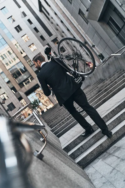 Business Man Carrying Bicycle While Walking Stairs — стоковое фото