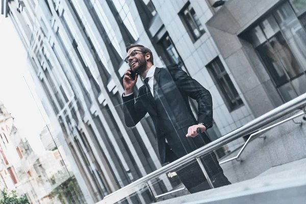 事務所ビルに立っている携帯電話で話している笑顔の実業家 — ストック写真