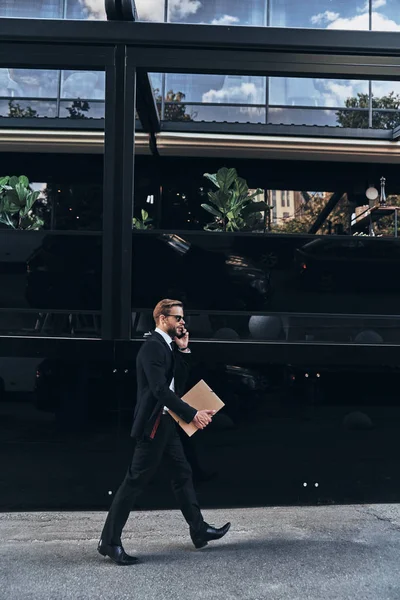Empresário Terno Completo Falando Telefone Celular Enquanto Caminha Livre Segurando — Fotografia de Stock