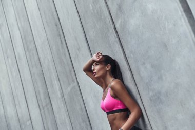 esmer kadın gri duvara yaslanmış ve ararken pembe top