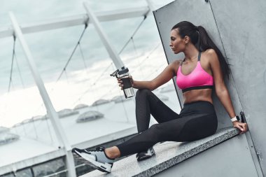 kadın çatıda bina ve su şişe tutan istirahat giyim spor 