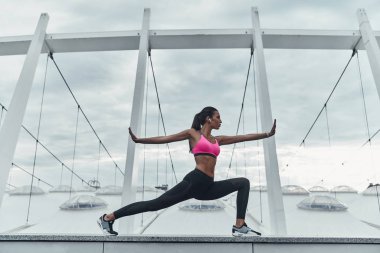sportif kadın açık havada modern binanın çatısına germe