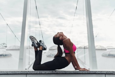 sportif kadın açık havada modern binanın çatısına germe